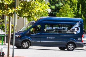 A Blue Jay shuttle van driving on the street.