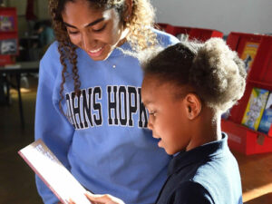 A young student working a Hopkins student