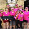 A group of students, wearing bright pink shirts.